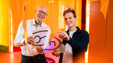 Zwei Personen im Escape-Room-Ambiente feiern lachend Geburtstag.